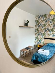 a mirror reflecting a bedroom with a bed and a bench at Vilvoorde city center in Vilvoorde