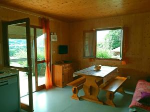 a room with a wooden table and a window at Gites dans La Prairie in Junhac