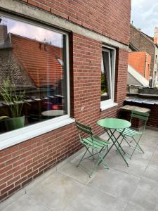 a patio with two chairs and a table in front of a brick building at Vilvoorde city center in Vilvoorde