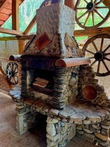 a large stone oven with a wooden roof with wheels at Girskiy Prutets in Bukovel