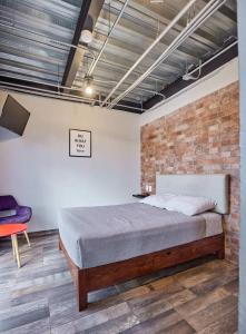 ein Schlafzimmer mit einem Bett und einer Ziegelwand in der Unterkunft R77 Habitación de Lujo Totalmente Equipada in Mexiko-Stadt