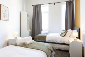 1 dormitorio con 2 camas y ventana en The Kingsway- 2 Bedroom Central Swansea Apartments By StayRight, en Swansea