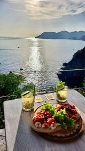 a pizza on a table with a view of the water at Affittacamere Le Terrazze in Corniglia