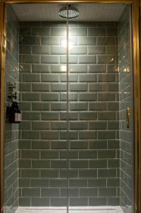 a shower with green subway tile in a bathroom at Sheddington Manor - 2 Bedroom Guest House & Cinema in Belfast