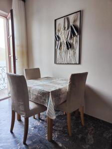 tavolo da pranzo con sedie e dipinto sul muro di Residenza Il Gabbiano 3 a Cannobio