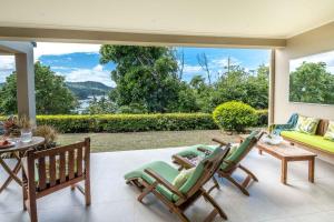 ein Wohnzimmer mit einem Sofa, Stühlen und einem Tisch in der Unterkunft La Bella Waters 3 - Oceanview's, Pool, Buggy and Transfers in Hamilton Island