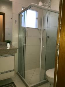 a glass shower in a bathroom with a toilet at Residencial Verano in Guarajuba