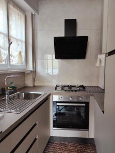 cocina con fogones, fregadero y fregadero en Residenza Il Gabbiano 3, en Cannobio