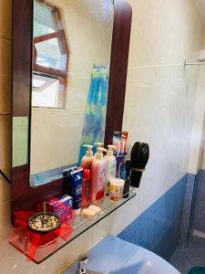 a bathroom sink with a mirror and a shelf with toiletries at ANTONIO TRANSIT KATUNAYAKE in Katunayake