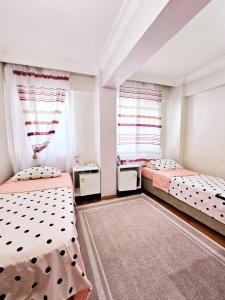 2 Betten in einem Zimmer mit 2 Fenstern in der Unterkunft Clover Flower House Only for Females ZEYTİNBURNU in Istanbul