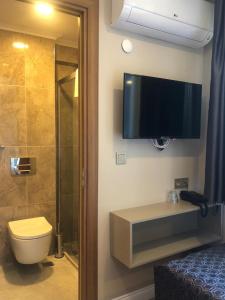 a bathroom with a toilet and a tv on the wall at Grand İska Hotel in Istanbul