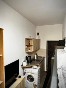 cocina pequeña con lavadora y cama en Ada's Luxury Apartment - Old City, en Brasov