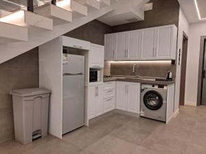 a kitchen with white cabinets and a washing machine at شاليهات راف in Khamis Mushayt