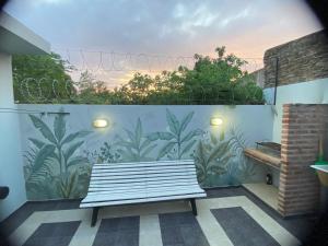 a white bench in front of a wall with a mural at Apartamento de luxe centro in Chascomús
