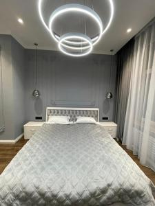 a bedroom with a large bed and a large chandelier at Doroshenka Premium Apartments in Lviv