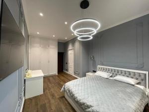 a bedroom with a large bed and a large light fixture at Doroshenka Premium Apartments in Lviv