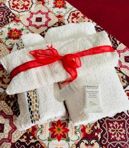 un mucchio di asciugamani bianchi con un fiocco rosso di I mori di Sicilia Relais Charme ad Altavilla Milicia