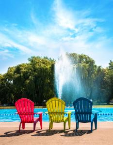 three colorful chairs sitting in front of a fountain at Vine Ridge Resort in Niagara on the Lake