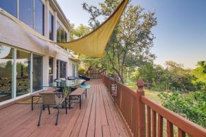 een houten terras met een tafel en stoelen erop bij Waterfront Lake Travis Luxury Home with Large Deck! in Spicewood