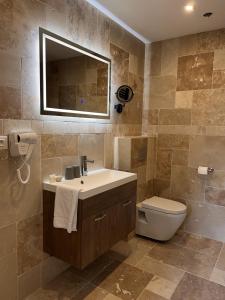 y baño con lavabo, aseo y espejo. en Hôtel La Pinède en Soulac-sur-Mer