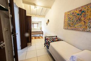 a room with two beds and a painting on the wall at Casa com Piscina a 100 m. de Camburizinho in Camburi