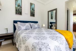 a bedroom with a bed with a blue and white comforter at Runaway Bay Gem Suite in Runaway Bay