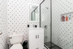 a bathroom with a toilet and a shower with a mirror at Runaway Bay Gem Suite in Runaway Bay