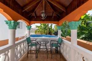 a porch with a table and chairs and a swimming pool at Runaway Bay Gem Suite in Runaway Bay