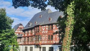 a large red and white building with a gray roof at Ferienwohnung Am Kurpark in Bad Camberg