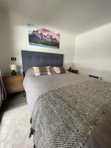 um quarto com uma cama e um quadro na parede em PuertoVaras410 em Puerto Varas