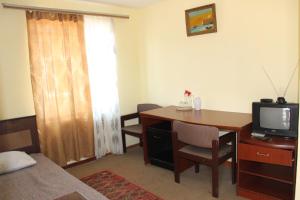 Cette chambre dispose d'un bureau, d'une télévision et d'une table. dans l'établissement Hotel Lori Berd, à Stepanavan