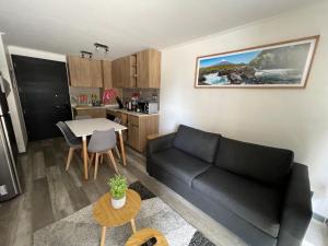 a living room with a black couch and a table at PuertoVaras410 in Puerto Varas