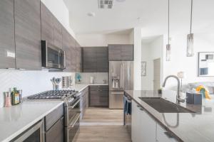 uma cozinha com utensílios de aço inoxidável e armários de madeira em Private Rooftop Terrance-Walk Score 81-Shopping District-King Bed-Parking 4021 em Scottsdale