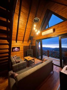 a living room with a couch and a fireplace at Moon House Bungalow in Rize