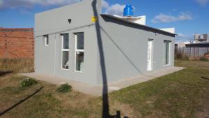 une maison blanche avec un poteau dans la cour dans l'établissement Alquiler por día Bahía Blanca, à Bahía Blanca