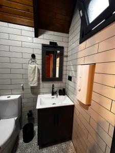 La salle de bains est pourvue d'un lavabo, de toilettes et d'un miroir. dans l'établissement Moon House Bungalow, à Rize