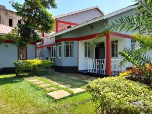 una casa colorida con un camino delante de ella en Milimani Comfort, en Kisumu