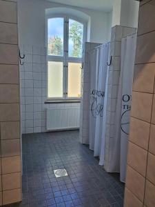 ein Bad mit weiß gefliesten Wänden und einem Fenster in der Unterkunft Stora Ekeberg vandrarhem in Axvall
