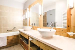 a bathroom with two sinks and a tub and a mirror at Stunning 3-bedroom apartment with mountain views in Flaine