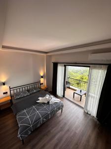 a bedroom with a bed and a large sliding glass door at Moon House Bungalow in Rize