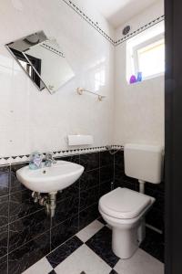 Baño blanco con aseo y lavamanos en Villa Andrea, en Koper