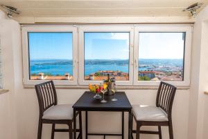 a table and two chairs in a room with a window at Villa Andrea in Koper