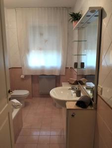 ein Badezimmer mit Waschbecken und Toilette und einem Fenster in der Unterkunft Dimora Poderina Cod Z01019 in Dueville