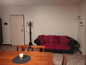ein Wohnzimmer mit einem roten Sofa und einem Tisch in der Unterkunft Dimora Poderina Cod Z01019 in Dueville
