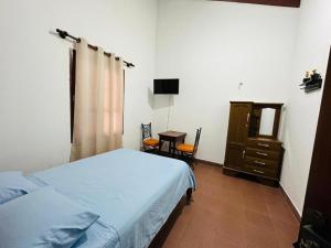 1 dormitorio con cama, tocador y mesa en Departamento 2 habitaciones Trinidad Beni en Trinidad