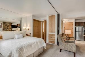 a bedroom with a white bed and a chair at Laurelwood Condominiums 302 in Snowmass Village