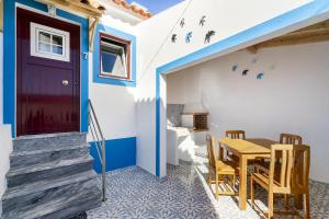 a house with a blue door and a table and chairs at Charming Amieira's Alqueva in Amieira