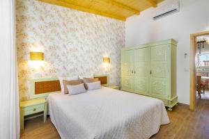 a bedroom with a white bed and a green cabinet at Charming Amieira's Alqueva in Amieira