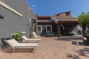 two lounge chairs on a patio in front of a house at Villa Rose Acireale Santa Tecla in Santa Tecla