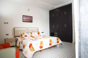 sypialnia z dużym łóżkiem i czarną szafką w obiekcie DMK Shared Apartments w mieście Abudża